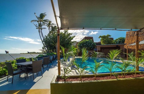Kaunakakai House | Your Ultimate Oceanfront Retreat | Relaxing Room with Lush Garden View